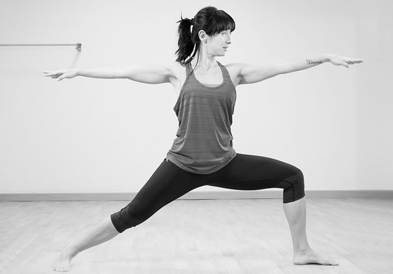 Dona en postura de ioga guerrer, entrenament Harmonia
